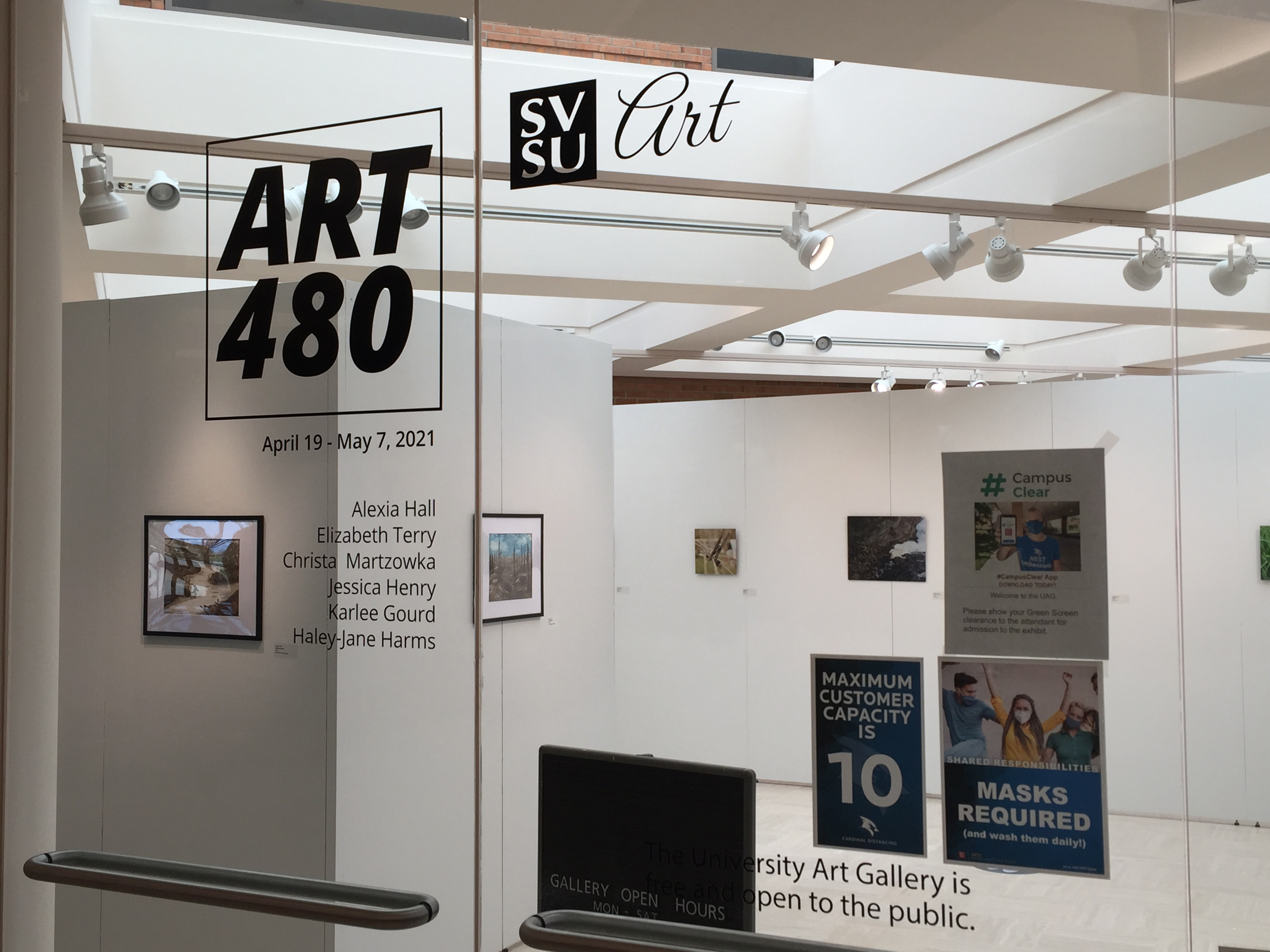 The art 480 banner on the glass with student participant names and artwork in the background